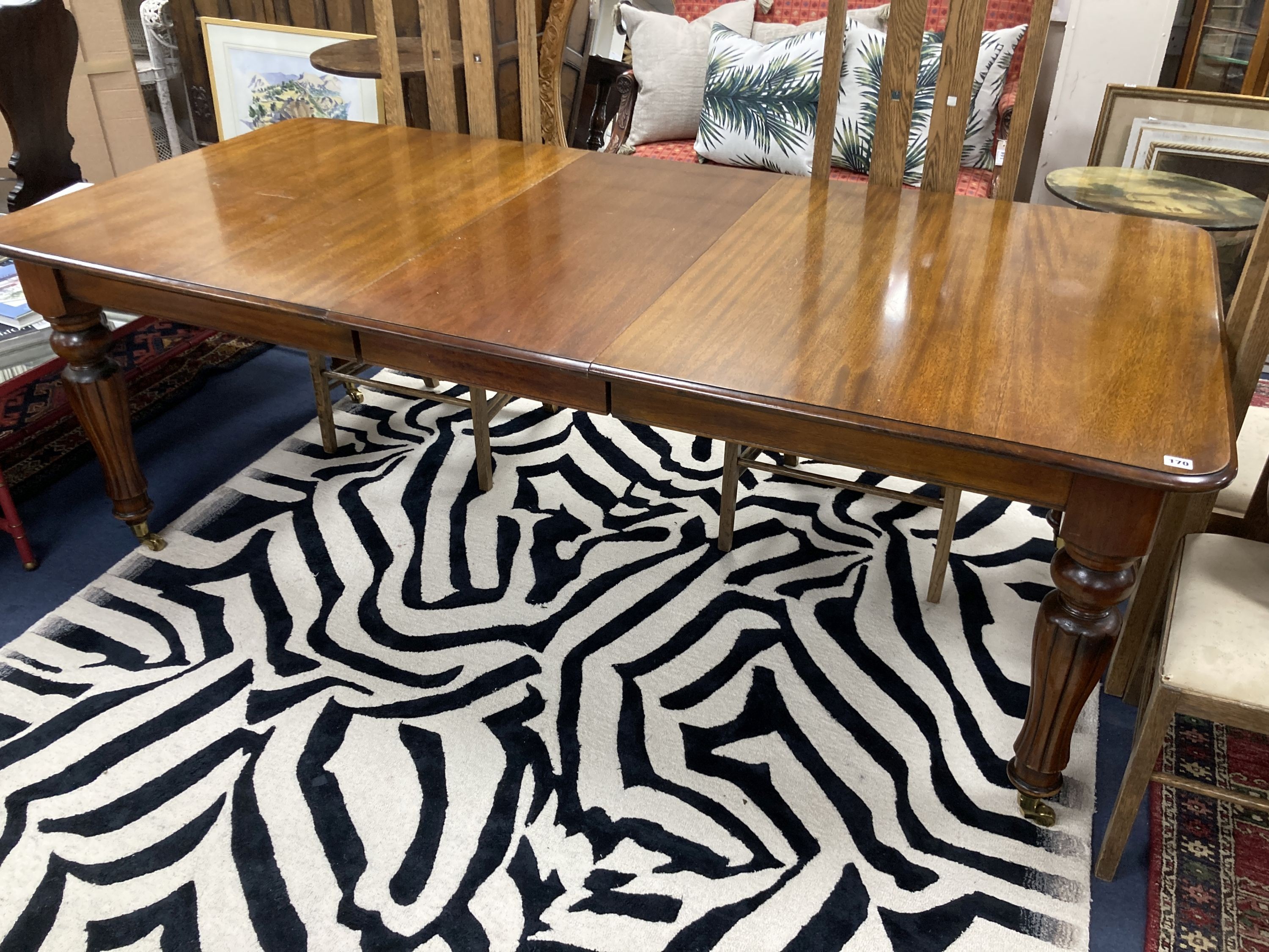 A Victorian style mahogany extending dining table. 214 extended, one spare leaf. W-100, H-74cm.